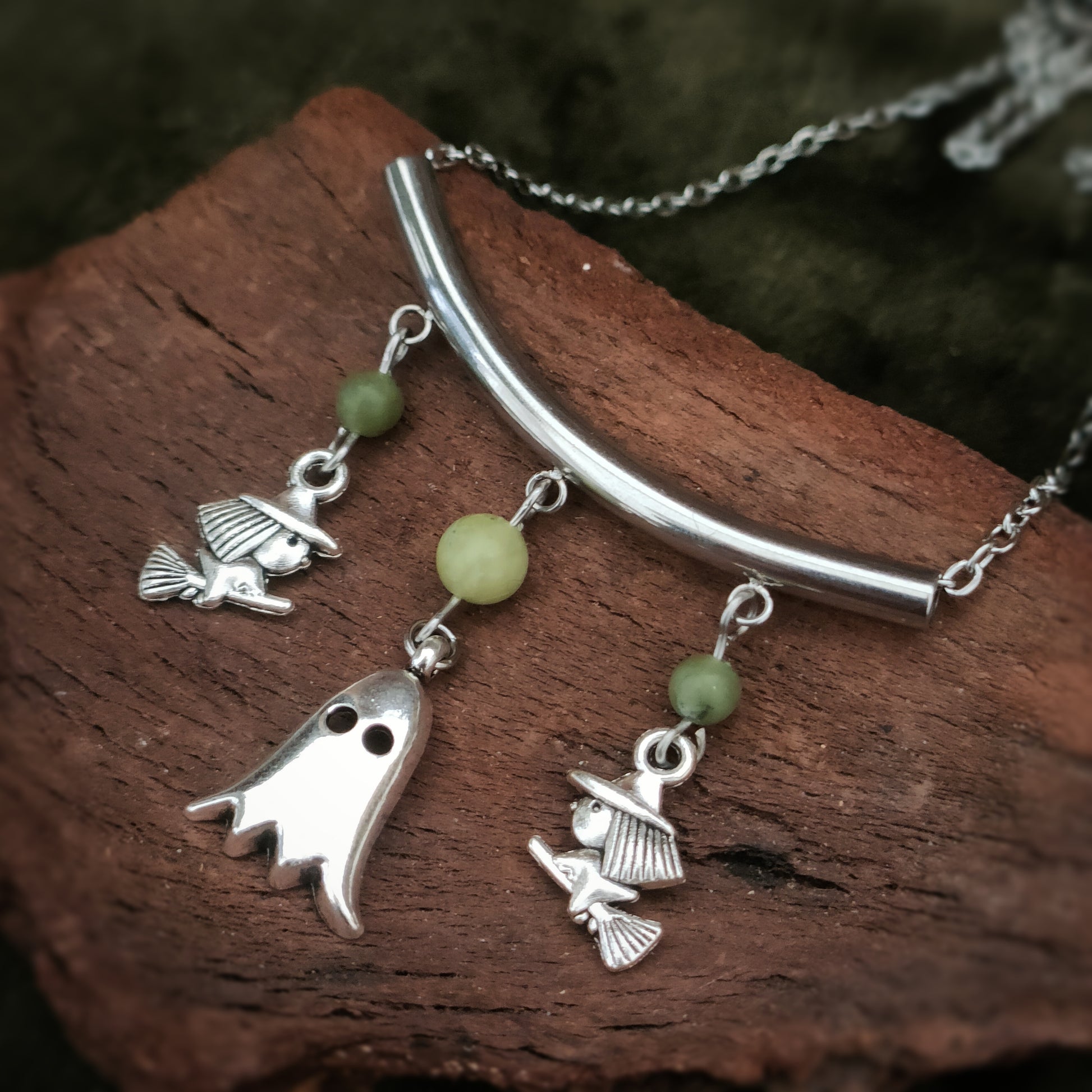 collier sur le theme d'halloween orné de perles de Serpentine et représentant deux petites sorcieres sur leur balais encadrant un fantome 